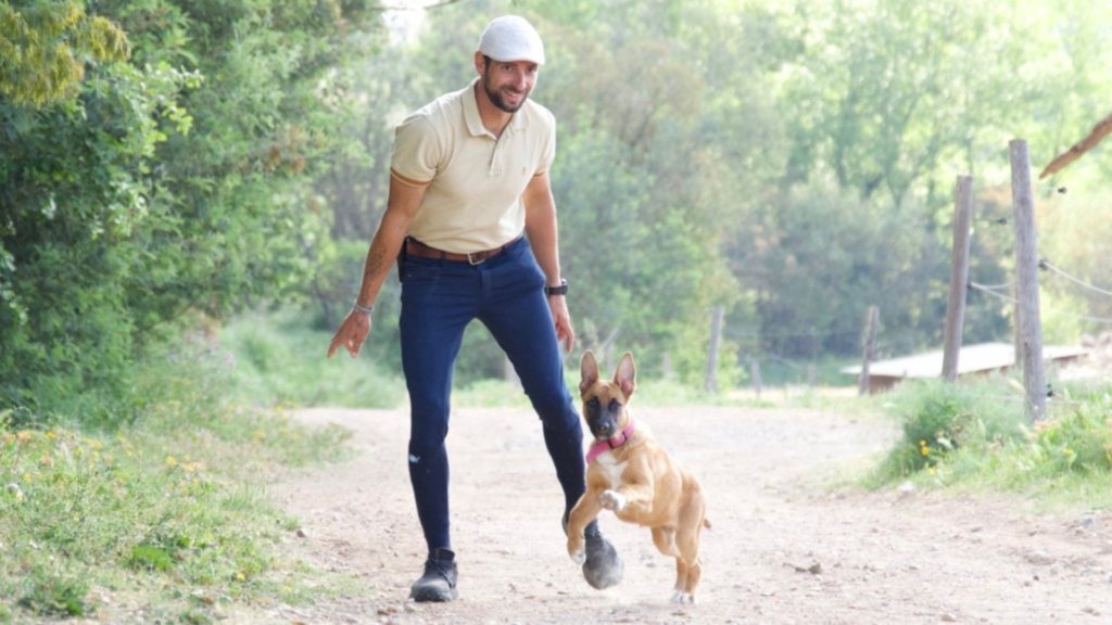 Killian souriant sur un chemin avec un chiot
